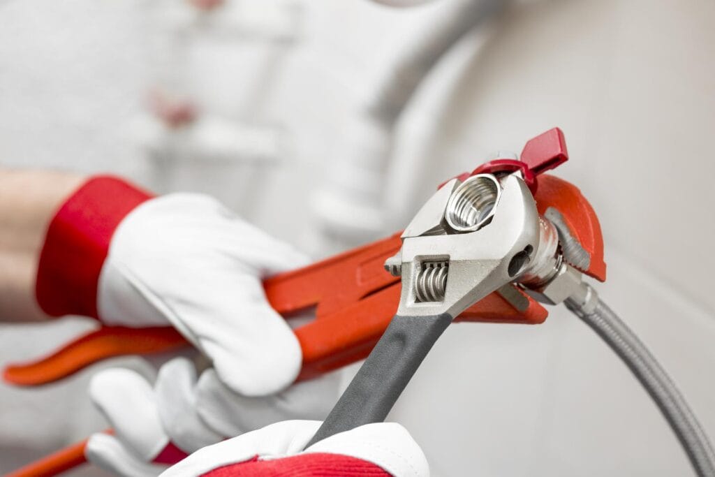 Plumber holding pipe wrenches for an emergency repair in Gilroy