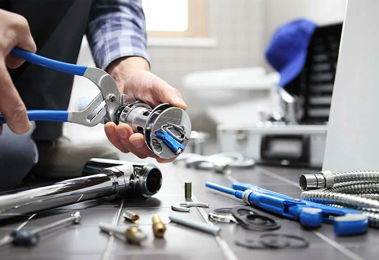 Technician repairing a plumbing fixture with professional tools in Gilroy