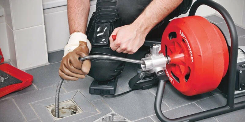 Plumber using a drain-cleaning machine in Gilroy