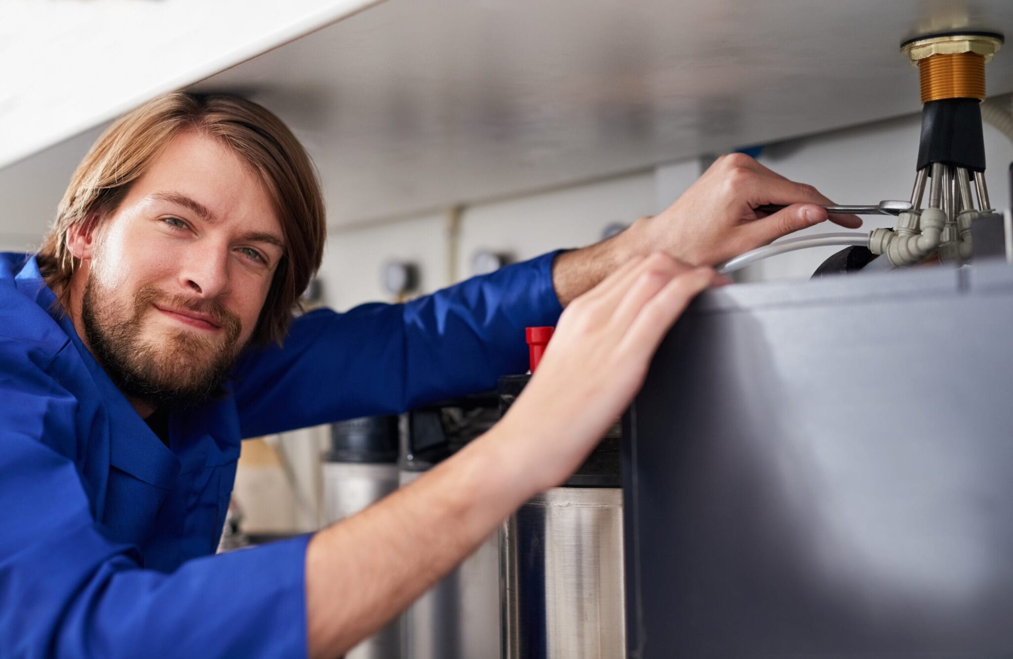 Technician servicing a residential water heater tank in Gilroy